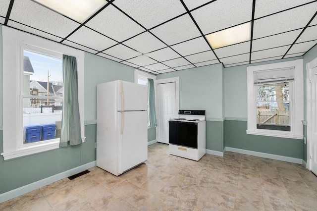 kitchen with a paneled ceiling, electric range, visible vents, baseboards, and freestanding refrigerator