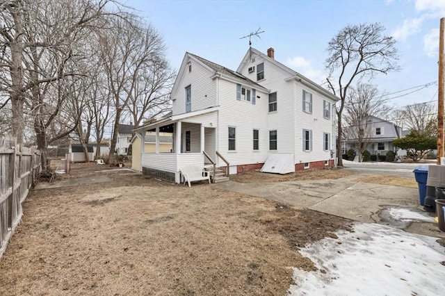 view of side of property with a chimney and fence