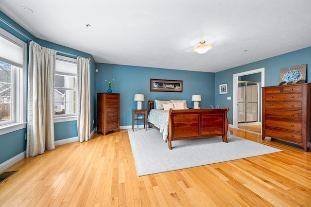 bedroom featuring baseboards, wood-type flooring, and visible vents