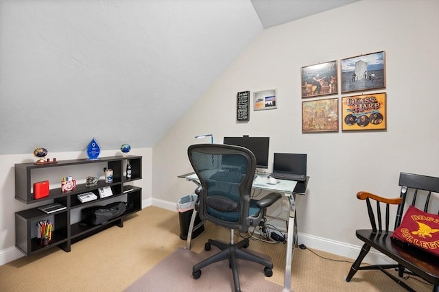 carpeted office with vaulted ceiling and baseboards