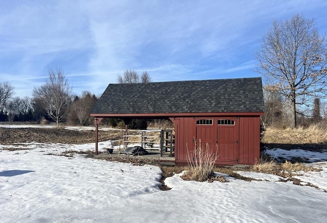 snow covered structure featuring a storage shed and an outdoor structure