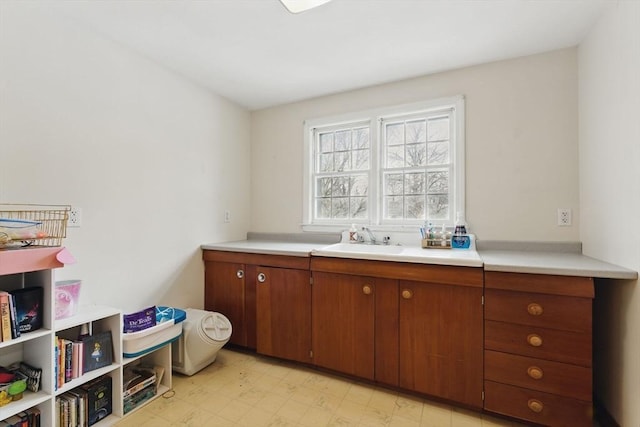 interior space with brown cabinets, light countertops, a sink, and light floors