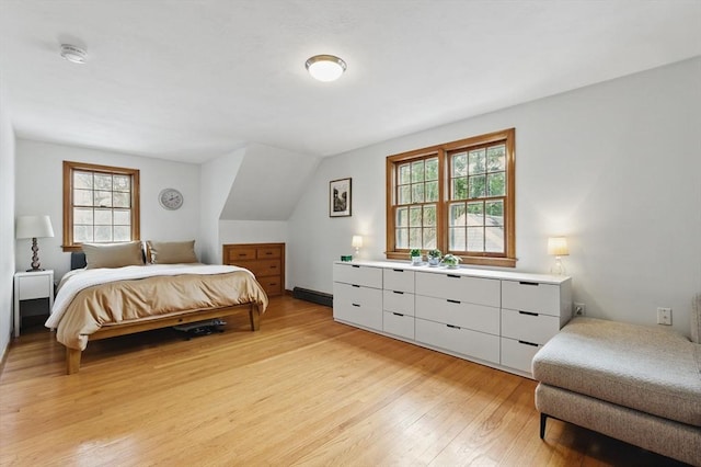 bedroom featuring light wood-style floors and lofted ceiling