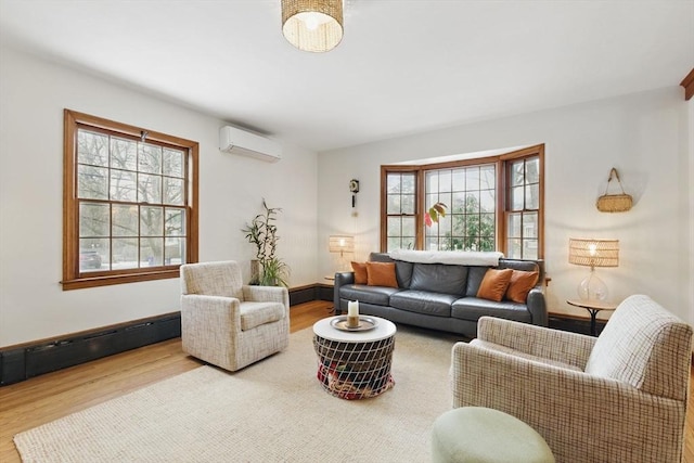 living room with baseboards, baseboard heating, an AC wall unit, and wood finished floors