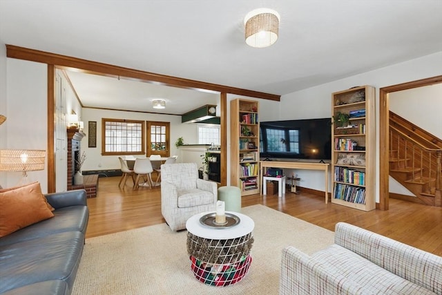 living room with stairway, wood finished floors, and ornamental molding