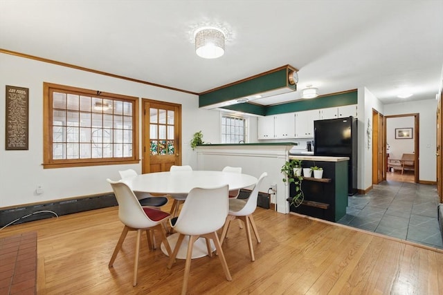 dining room featuring crown molding, dark wood-type flooring, and baseboards