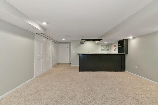 finished basement featuring wet bar, recessed lighting, light colored carpet, and baseboards