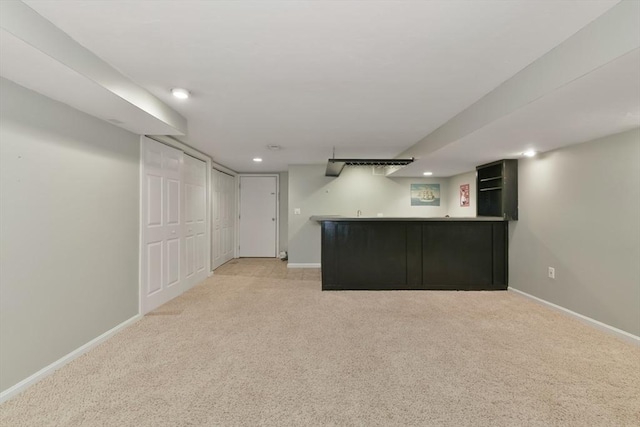 finished below grade area with recessed lighting, wet bar, baseboards, and light colored carpet