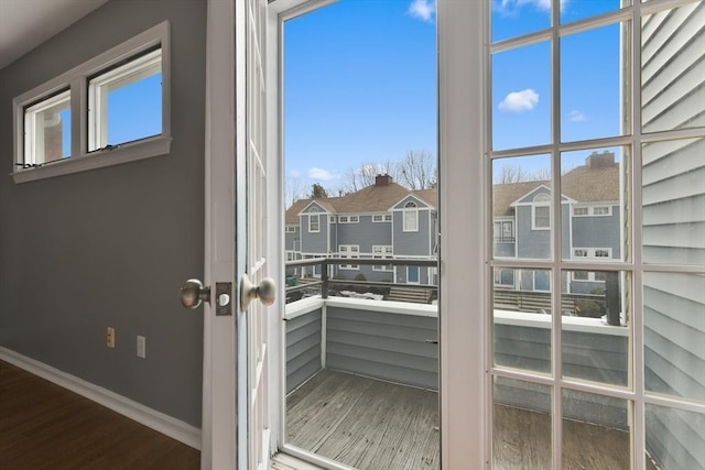 entryway with a residential view, baseboards, and wood finished floors