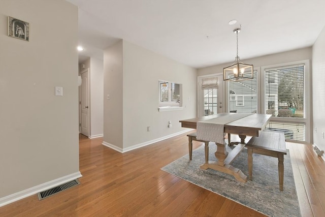 dining space with light wood-type flooring, baseboards, and visible vents