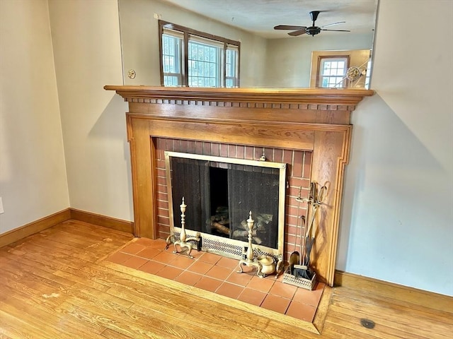 details featuring ceiling fan, wood-type flooring, and a fireplace