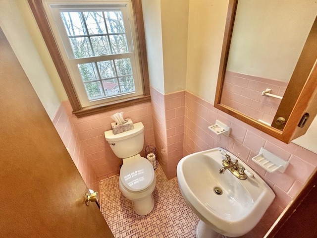 bathroom with toilet, tile walls, sink, and tile patterned flooring