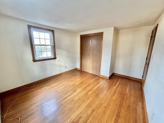 unfurnished bedroom featuring light hardwood / wood-style floors and a closet