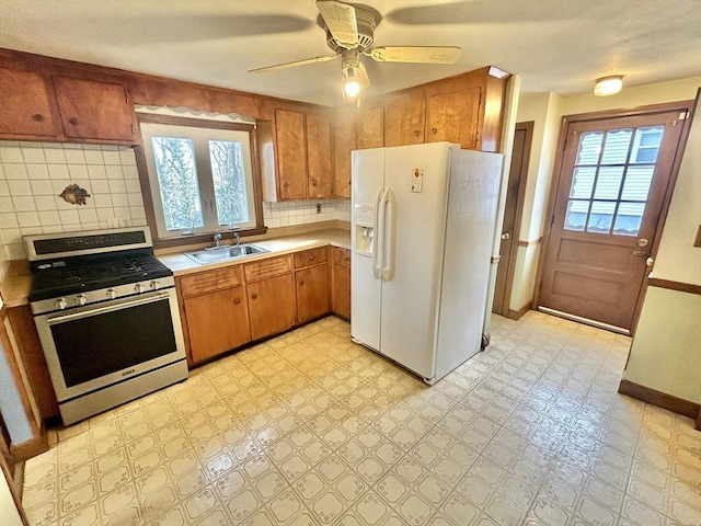 kitchen with white refrigerator with ice dispenser, plenty of natural light, stainless steel range with gas cooktop, and sink