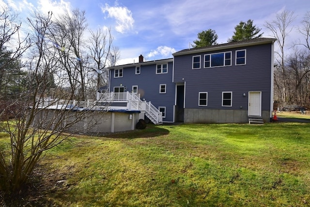 back of house featuring a lawn and a swimming pool