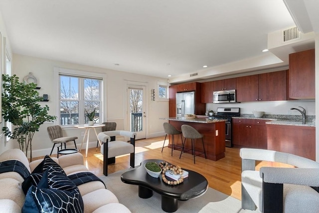 living room with light hardwood / wood-style floors and sink