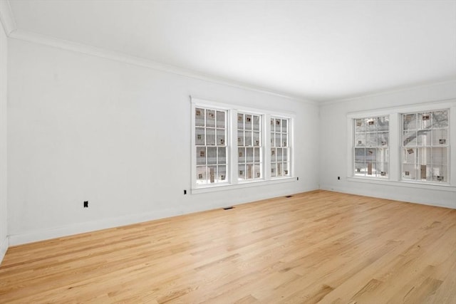 empty room featuring crown molding and light hardwood / wood-style flooring