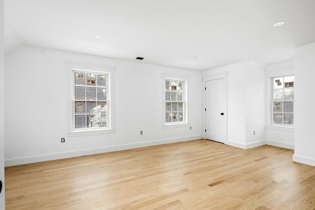 unfurnished room featuring vaulted ceiling and light hardwood / wood-style floors