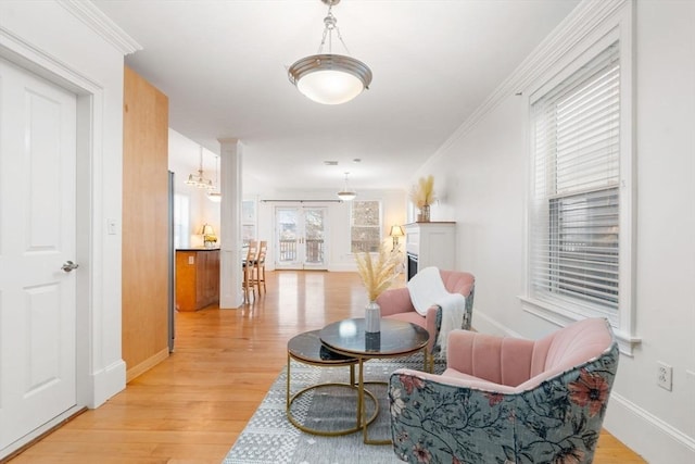 living area with light hardwood / wood-style flooring and ornamental molding