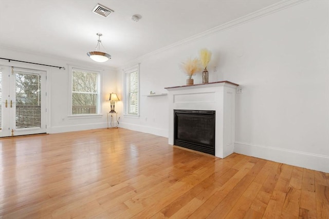 unfurnished living room featuring crown molding, plenty of natural light, and light wood-type flooring