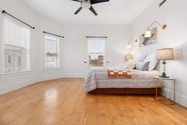 bedroom featuring multiple windows, ceiling fan, and wood-type flooring