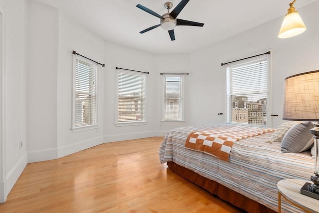 bedroom featuring multiple windows, ceiling fan, and hardwood / wood-style floors