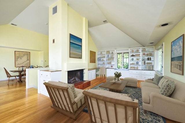 26 N Shore Dr Unit 7, Dartmouth, MA 02748 - living room featuring lofted ceiling, light wood-style floors, a brick fireplace, and built in features