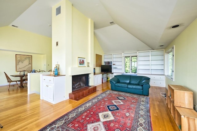 26 N Shore Dr Unit 7, Dartmouth, MA 02748 - living room with vaulted ceiling, light wood finished floors, built in features, and a glass covered fireplace