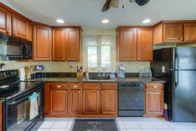 kitchen with light tile patterned floors, dark stone countertops, black appliances, and sink