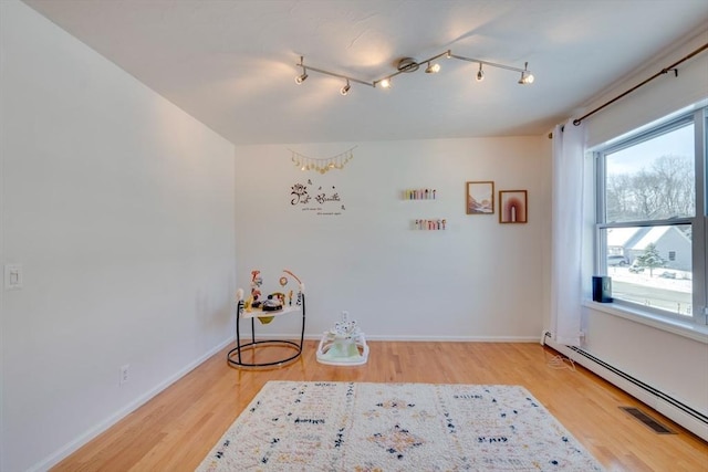 interior space with hardwood / wood-style floors and a baseboard heating unit