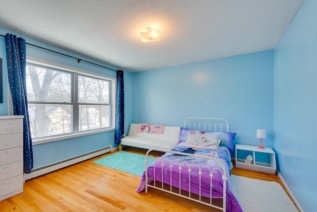 bedroom with a baseboard radiator and hardwood / wood-style floors