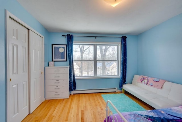 unfurnished bedroom with a baseboard radiator, light hardwood / wood-style floors, and a closet