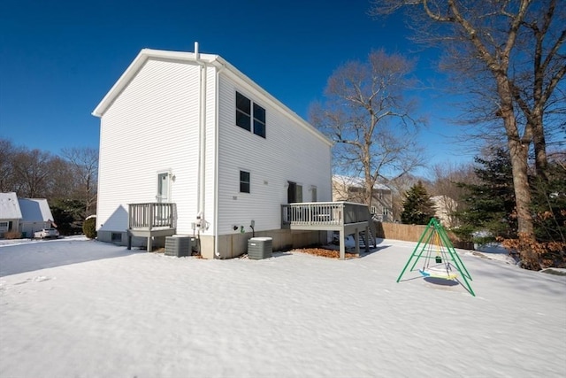 snow covered property with a wooden deck and central air condition unit