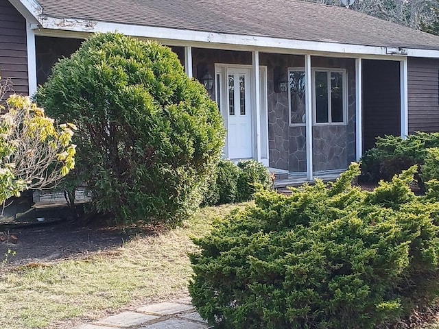 property entrance featuring a shingled roof