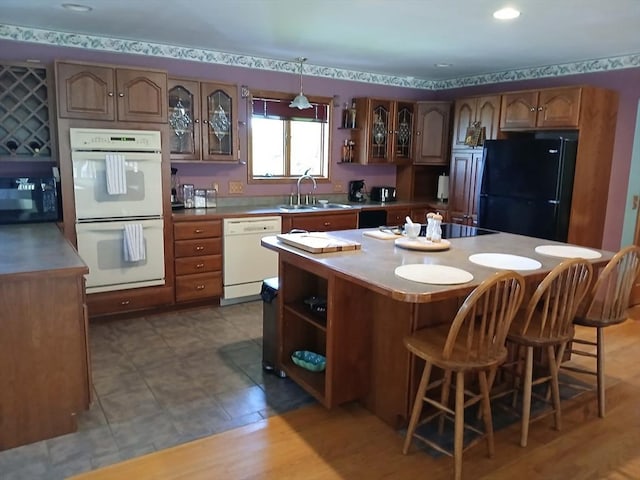 kitchen featuring a kitchen breakfast bar, a center island, open shelves, a sink, and black appliances
