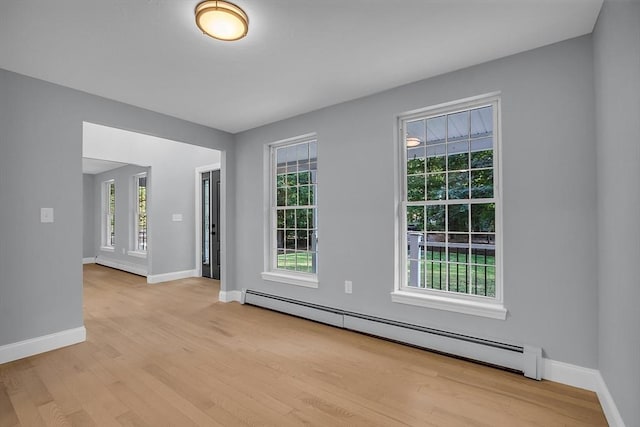 spare room with light hardwood / wood-style flooring, a healthy amount of sunlight, and baseboard heating