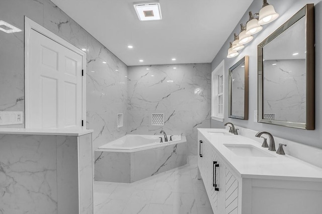 bathroom featuring vanity and tiled tub