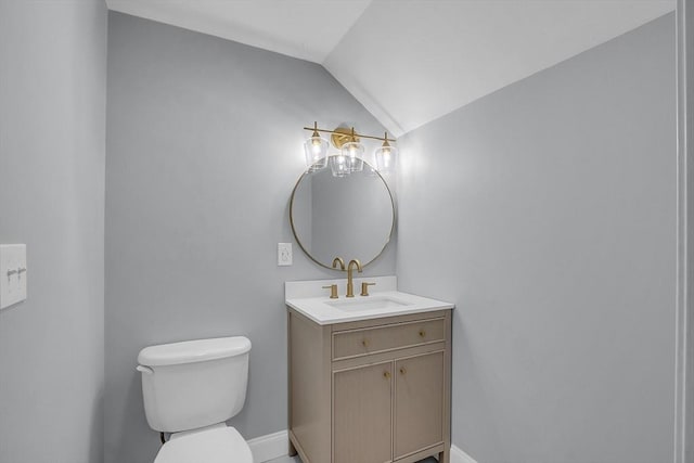 bathroom with vanity, toilet, and vaulted ceiling