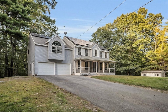 view of front of property featuring a garage, a front lawn, covered porch, and solar panels