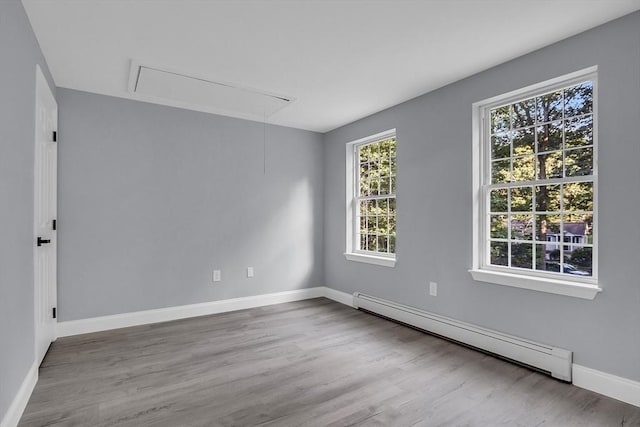 unfurnished room with hardwood / wood-style flooring and a baseboard radiator