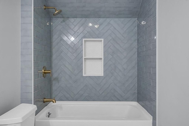 bathroom with tiled shower / bath combo and toilet