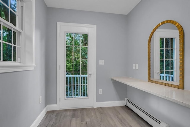 entryway with baseboard heating and light wood-type flooring