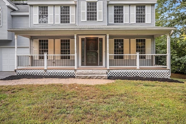 view of front of property featuring a porch, a garage, and a front yard