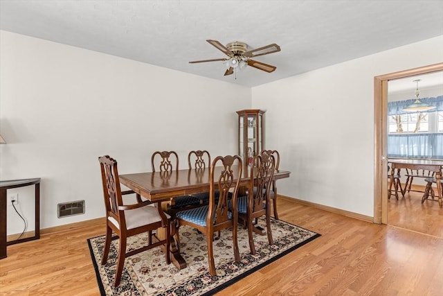 dining area featuring visible vents, baseboards, light wood-style flooring, and a ceiling fan