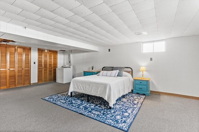 carpeted bedroom featuring washer / dryer and baseboards