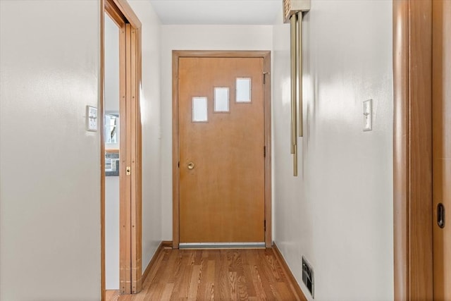 hall featuring light wood finished floors and visible vents