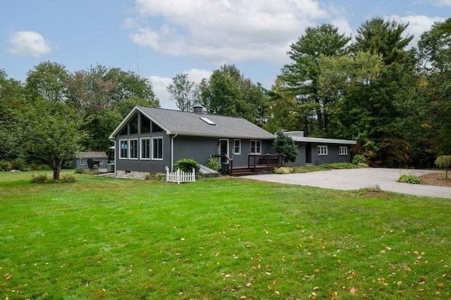 back of property featuring a yard and a wooden deck