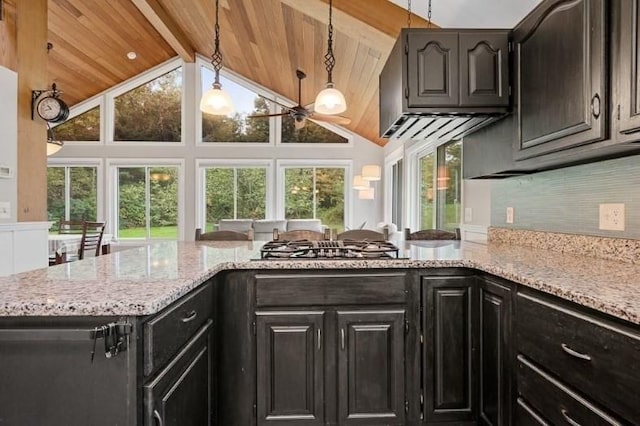 kitchen featuring wooden ceiling, stainless steel gas cooktop, vaulted ceiling with beams, light stone counters, and decorative backsplash