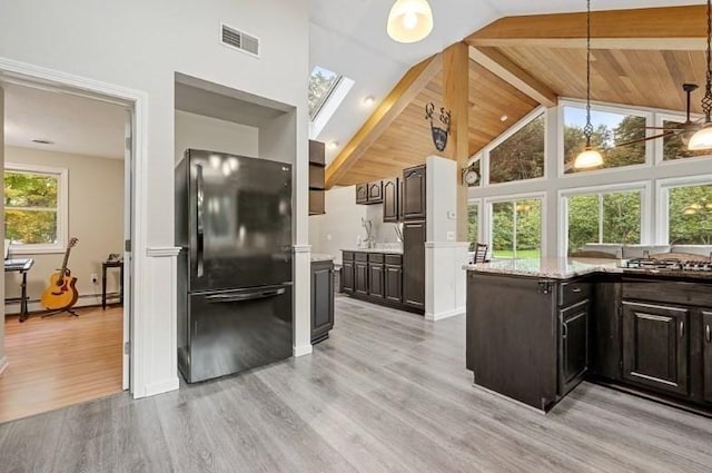 kitchen featuring beamed ceiling, black refrigerator, light wood-type flooring, and dark brown cabinetry