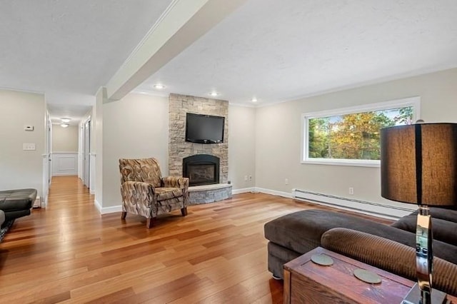 living room with crown molding, wood-type flooring, a fireplace, and baseboard heating